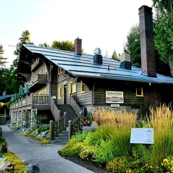 outside view of Belton Chalet Glacier National Park with wooden outside, deck and landscaping around it