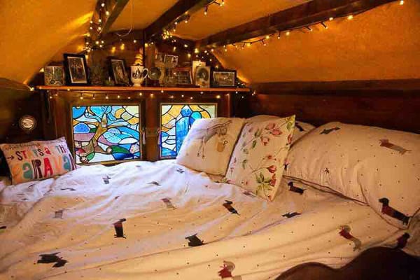 Gypsy Glamping Wagon view from inside of a bed and stained glass window