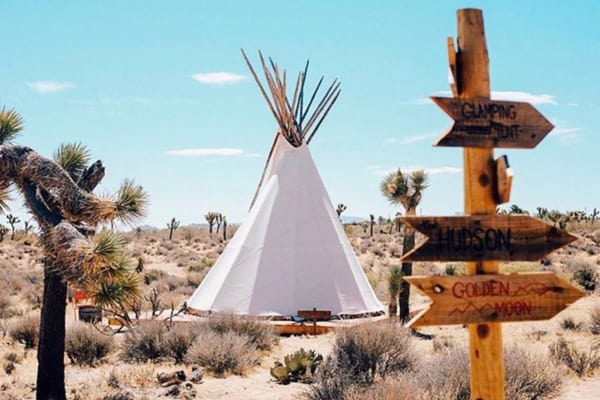 The Raising Sun Glamping Tipi at Lazy Sky view of tipi with sign in front in the desert