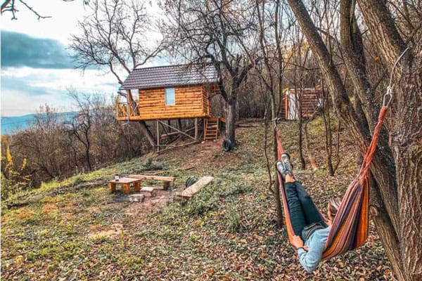 Transylvania Treehouse Romania view of glamping romania treehouse with a view and person hanging in hammock