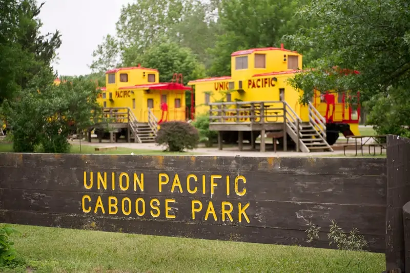 Two Rivers Area Glamping Train Caboose view of union pacific sign with yellow cabooses in the background