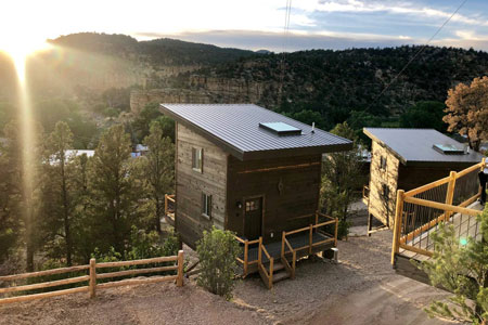 Top Glamping in Zion National Park to Love 12 view of two east zion glamping treehouses at sunset on a hill side